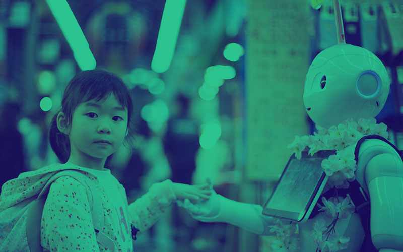 Little girl holding a robots hand