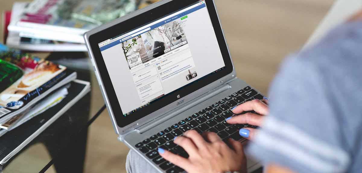 Woman looking at Facebook on her laptop